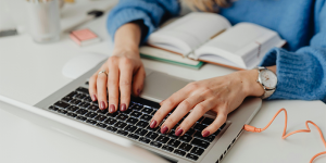 How to complete a unit in four weeks- a woman typing on a laptop and referencing a notebook